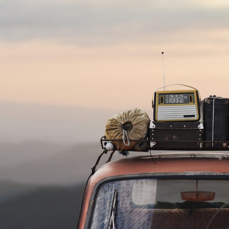 traveler car with roof rack and things in retro style on mountai